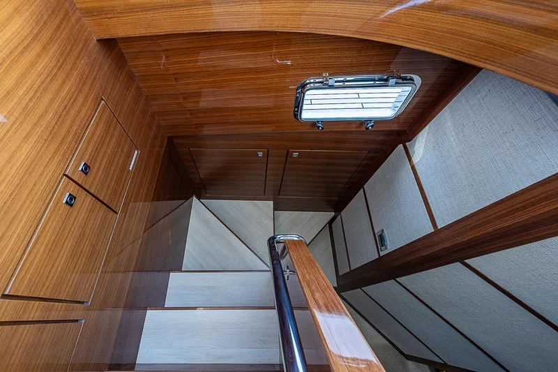 Slide: The Image of Staircase inside 2022 Summit 54 Motoryacht with wooden finish and porthole window. - 36