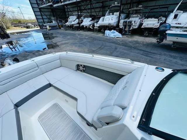 Slide: The Image of 2024 Sea Ray 270 SDX boat interior with white seating in a marina. - 24