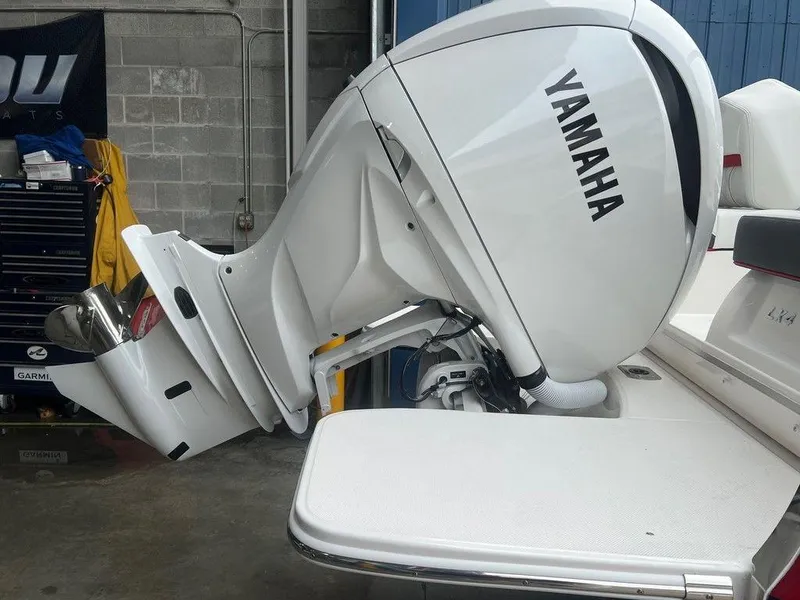 Slide: The Image of 2024 Regal LX4 boat with Yamaha outboard motor in a garage. - 12