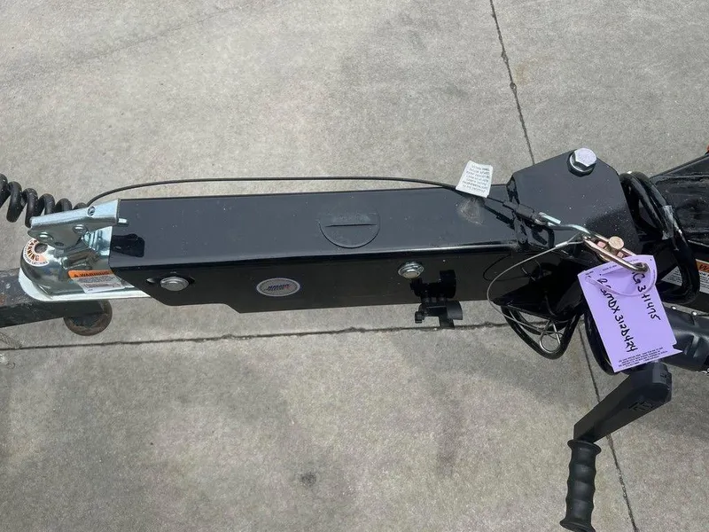 Slide: The Image of 2024 Regal LX4 trailer hitch with safety tags on concrete surface. - 18