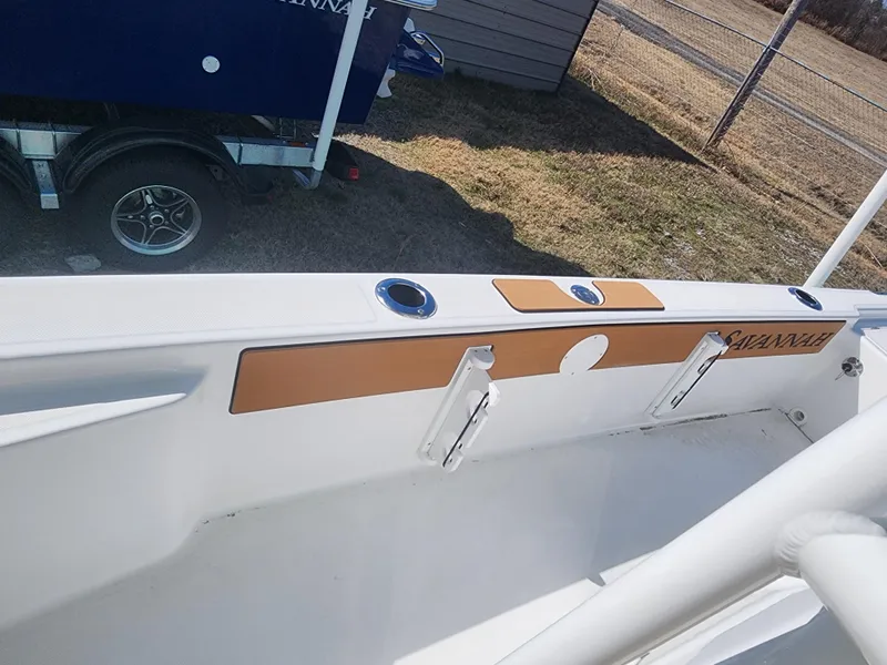 Slide: The Image of 2024 Savannah 220 IS boat interior with rod holders and storage compartments. - 22