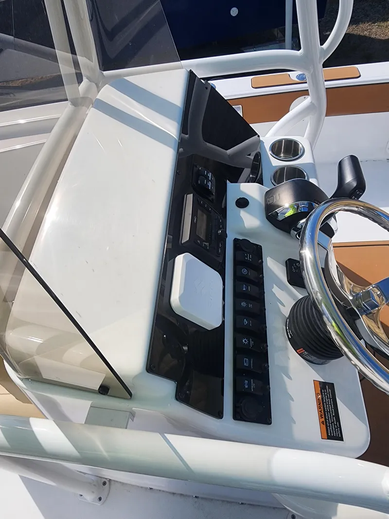 Slide: The Image of 2024 Savannah 220 IS boat console with steering wheel and control panel. - 24