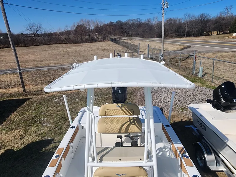 Slide: The Image of 2024 Savannah 220 IS boat with T-top and dual seats, parked on grass. - 27