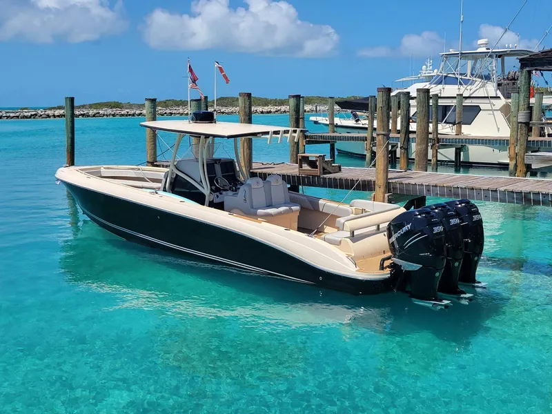 Slide: The Image of 2013 Statement 38 SUV Open boat docked in clear turquoise water. - 12