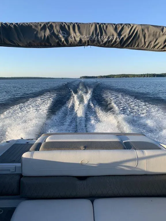 Slide: The Image of Crownline 215 SS 2020 model boat cruising on a lake, leaving a wake. - 9