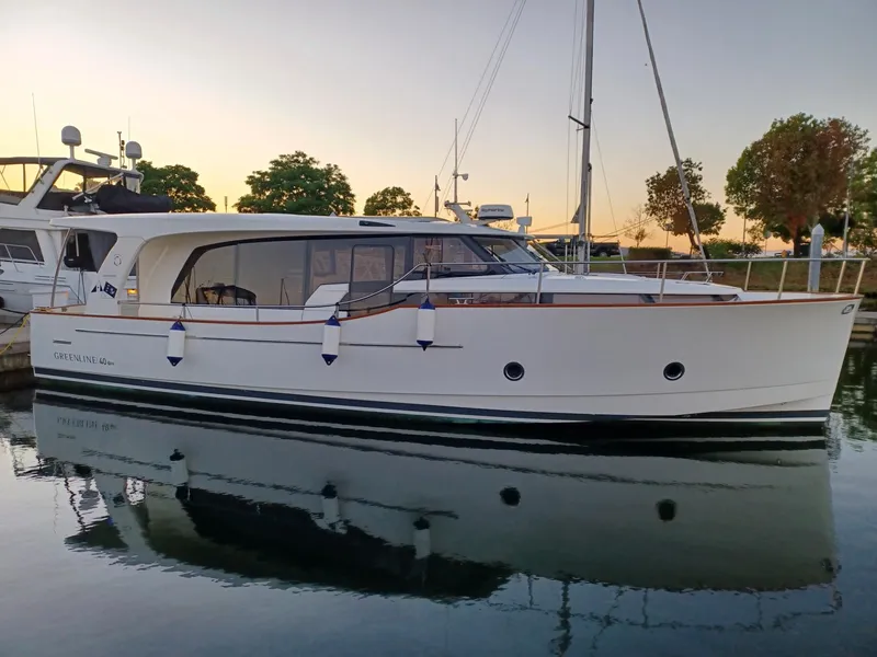 The Image of 2020 Greenline 40 yacht docked at sunset, reflecting on calm water. - 0