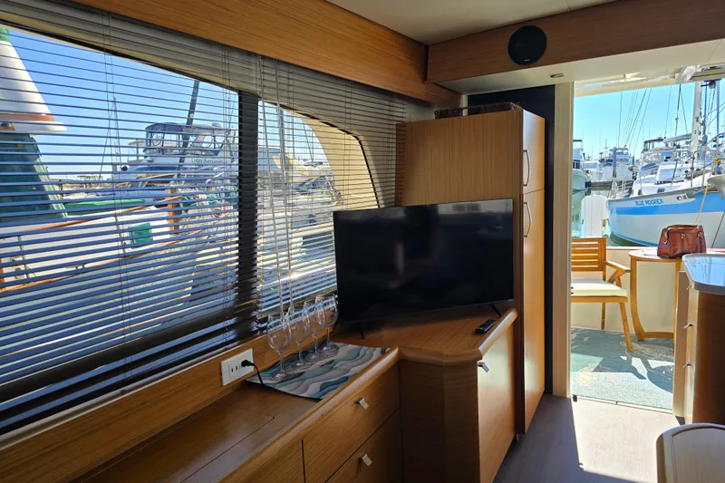 Slide: The Image of Interior of 2020 Greenline 40 yacht with TV, wooden cabinets, and marina view. - 12