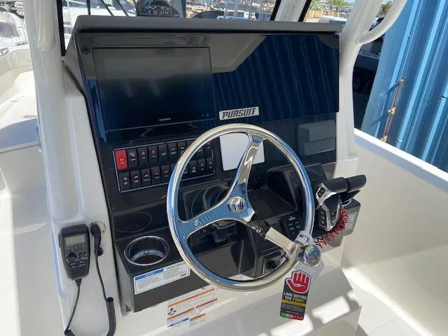 Slide: The Image of 2024 Pursuit S 268 boat dashboard with steering wheel and control panel. - 17