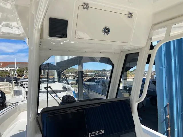 Slide: The Image of 2024 Pursuit S 268 boat interior with dashboard and storage compartment. - 18