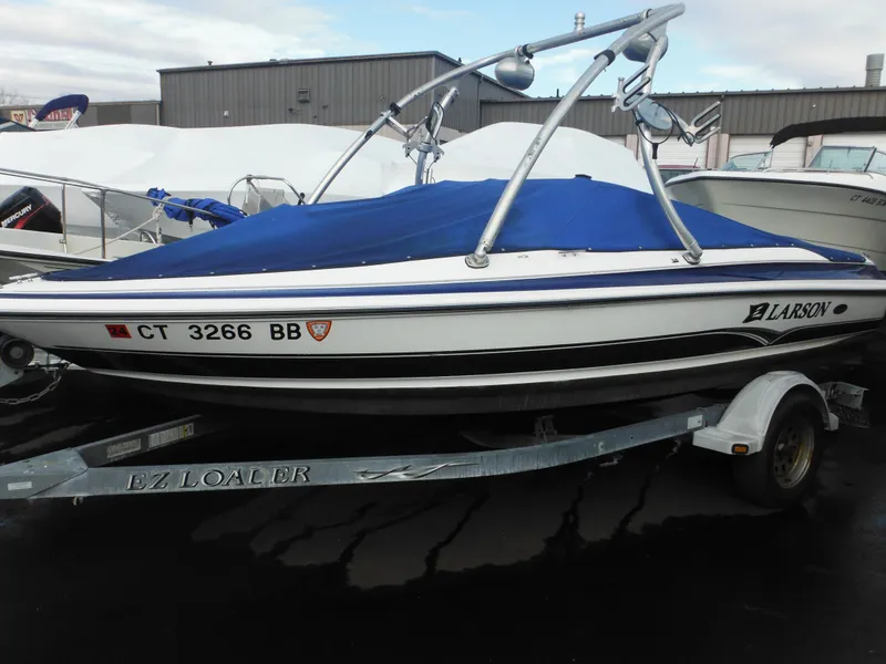 Slide: The Image of 2006 Larson SEi 180 Sport I/O boat on EZ Loader trailer with blue cover. - 1
