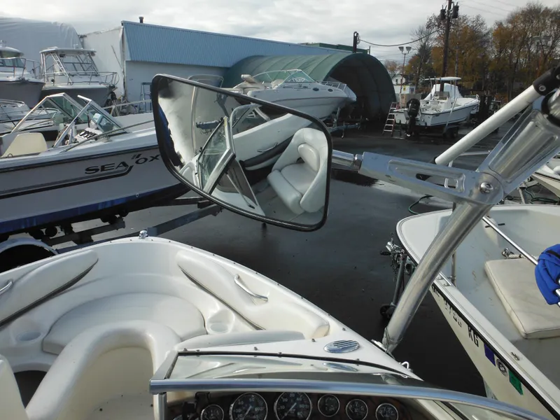 Slide: The Image of 2006 Larson SEi 180 Sport I/O boat interior and rearview mirror at a marina. - 29