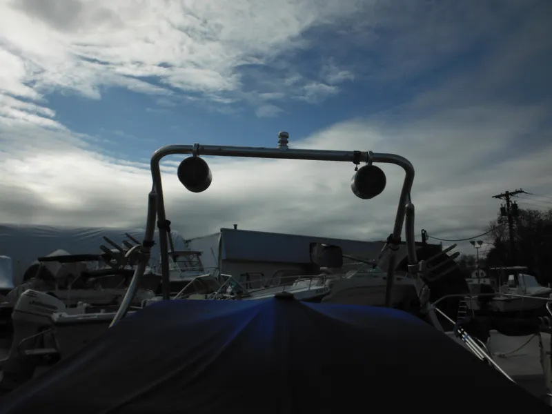 Slide: The Image of 2006 Larson SEi 180 Sport I/O boat in a marina under a cloudy sky. - 8