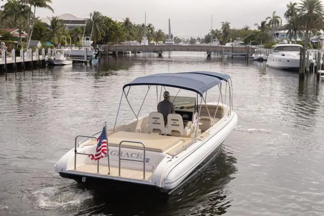 Slide: The Image of 2007 Novurania Chase boat cruising on a calm waterway with canopy and American flag. - 12