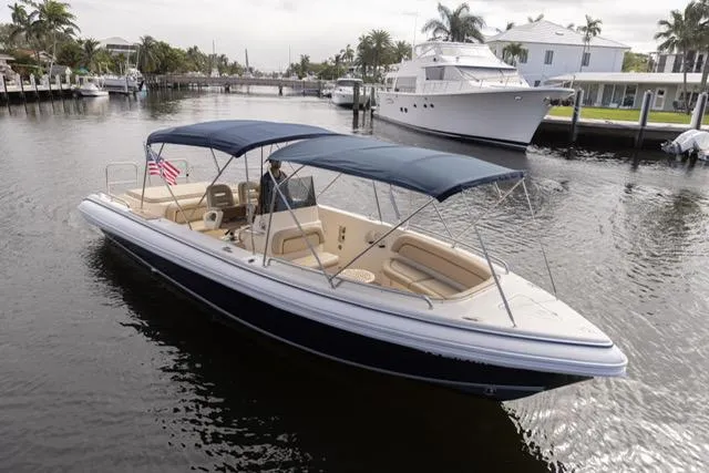 Slide: The Image of 2007 Novurania Chase boat with blue canopy cruising on a calm waterway. - 6