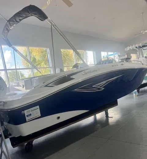 Slide: The Image of 2024 Hurricane 218 SS boat in showroom, blue and white design. - 2