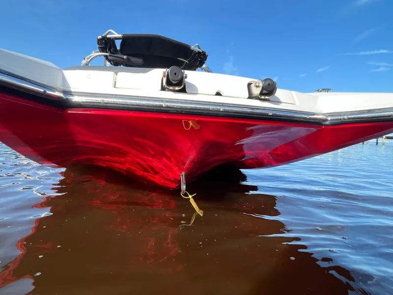 Slide: The Image of 2009 MasterCraft MariStar 230 boat with red hull on water. - 3