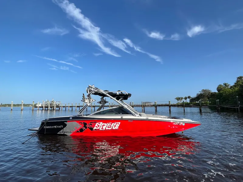 Slide: The Image of 2009 MasterCraft MariStar 230 red boat on calm water with blue sky. - 4