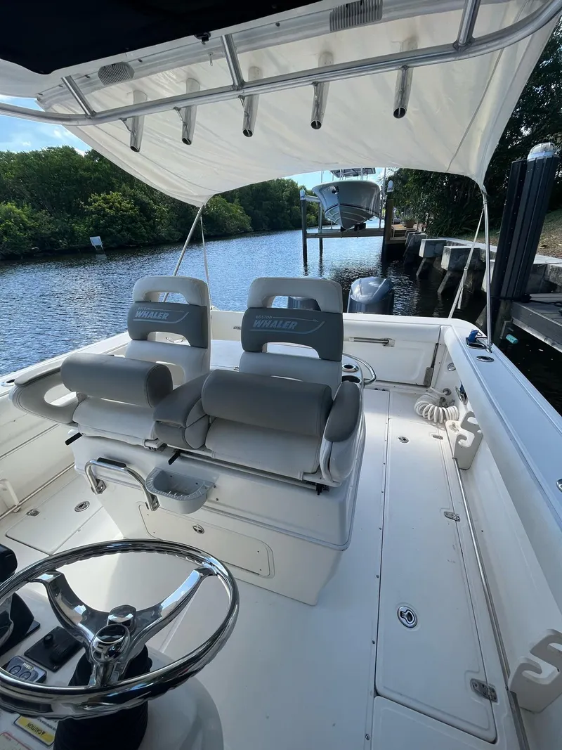 Slide: The Image of 2006 Boston Whaler 320 Outrage Cuddy Cabin with dual seating and canopy on a calm waterway. - 12
