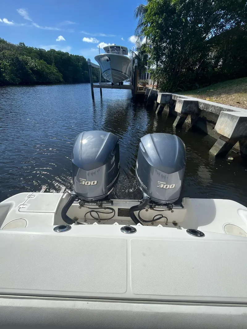 Slide: The Image of 2006 Boston Whaler 320 Outrage Cuddy Cabin with twin 300 HP engines on a calm waterway. - 13