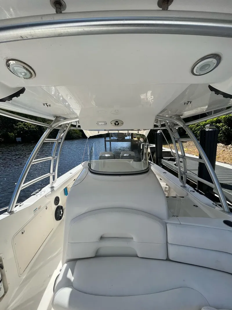 Slide: The Image of 2006 Boston Whaler 320 Outrage Cuddy Cabin, sleek interior, docked by a serene waterway. - 15