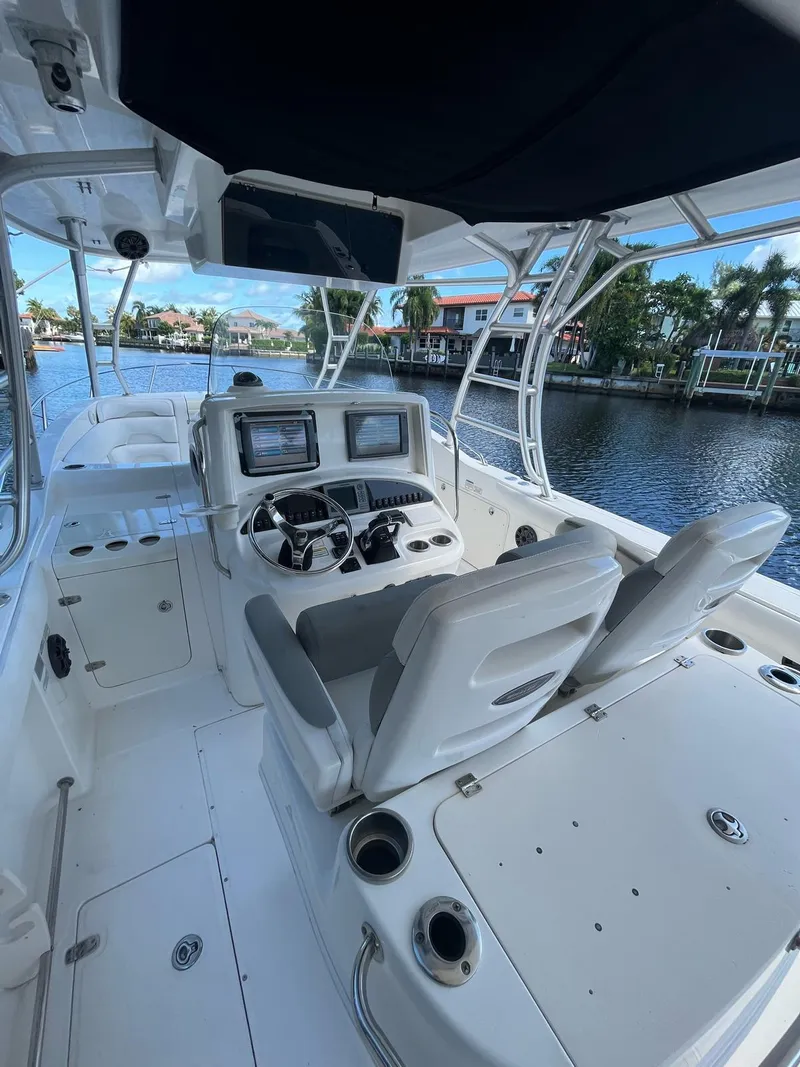 Slide: The Image of 2006 Boston Whaler 320 Outrage Cuddy Cabin with modern helm, docked by waterfront homes. - 7