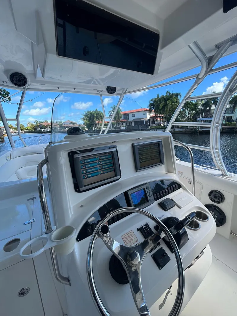 Slide: The Image of 2006 Boston Whaler 320 Outrage Cuddy Cabin helm with dual displays and steering wheel. - 8