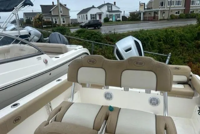 Slide: The Image of 2020 Key West 239 FS boat with beige seating, parked near coastal homes. - 10