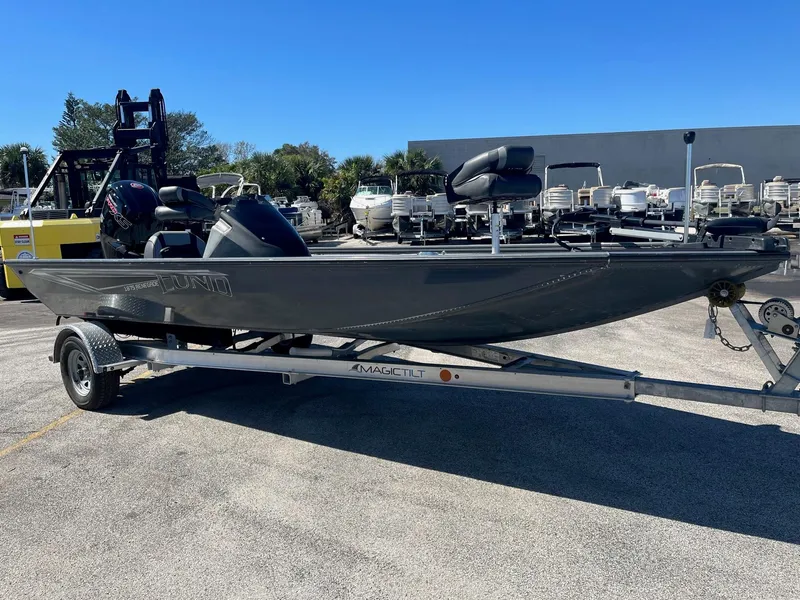 Slide: The Image of 2020 Lund 1875 Predator fishing boat on a trailer in a parking lot. - 2