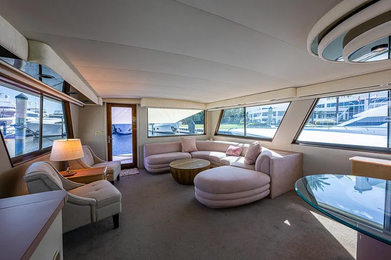 Slide: The Image of Luxurious interior of 1986 Hatteras 72 Motor Yacht with plush seating and panoramic windows. - 15