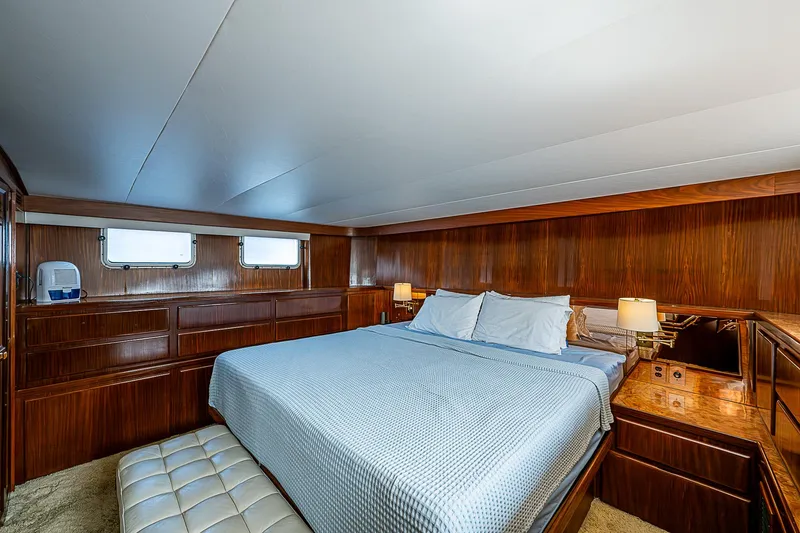 Slide: The Image of Luxurious bedroom interior of 1986 Hatteras 72 Motor Yacht with wood paneling and cozy bedding. - 28