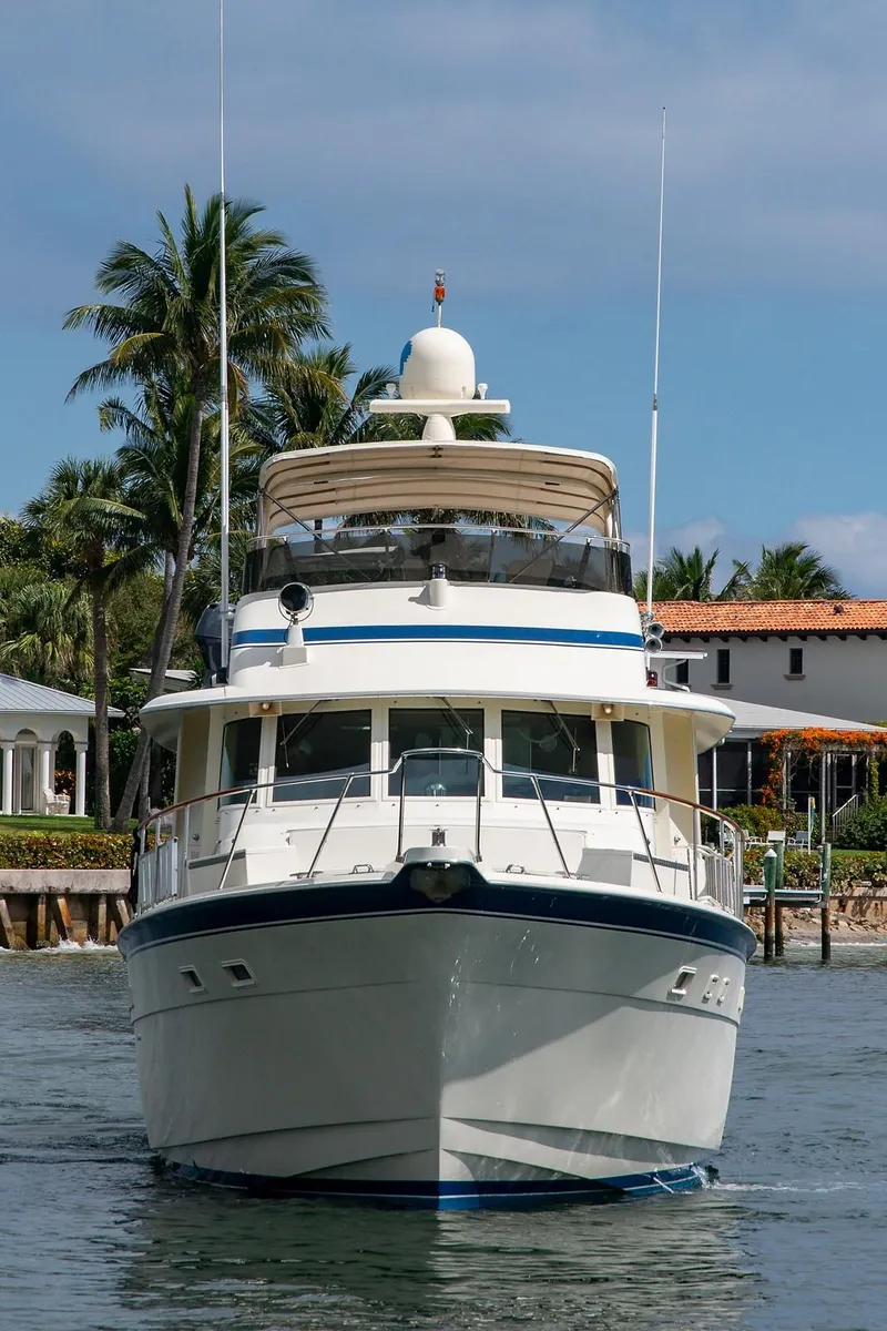 Slide: The Image of 1986 Hatteras 72 Motor Yacht cruising near waterfront homes. - 3
