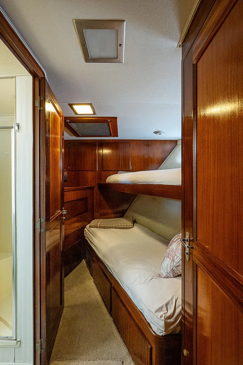 Slide: The Image of 1986 Hatteras 72 Motor Yacht cabin with wooden bunk beds and cozy interior. - 34