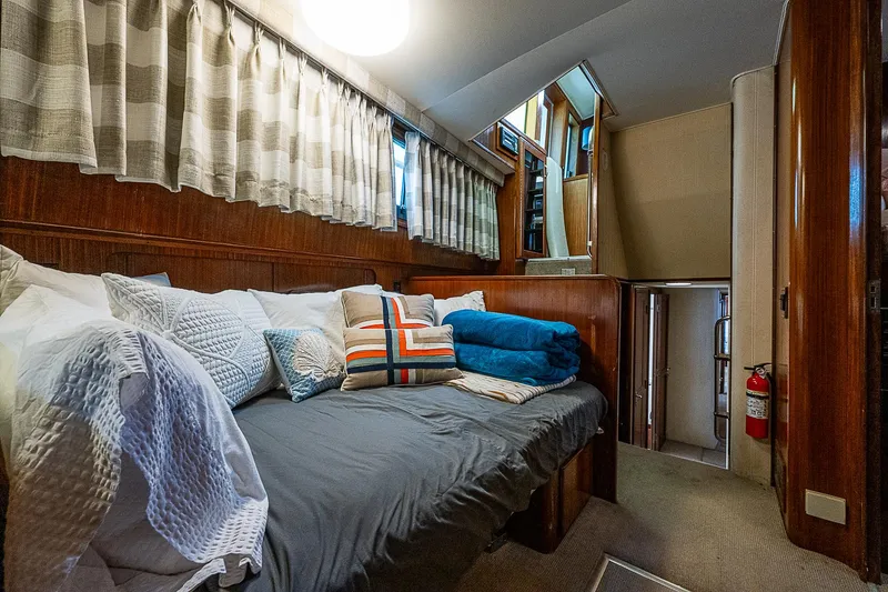 Slide: The Image of Cozy cabin interior of 1986 Hatteras 72 Motor Yacht with plush bedding and wood paneling. - 43