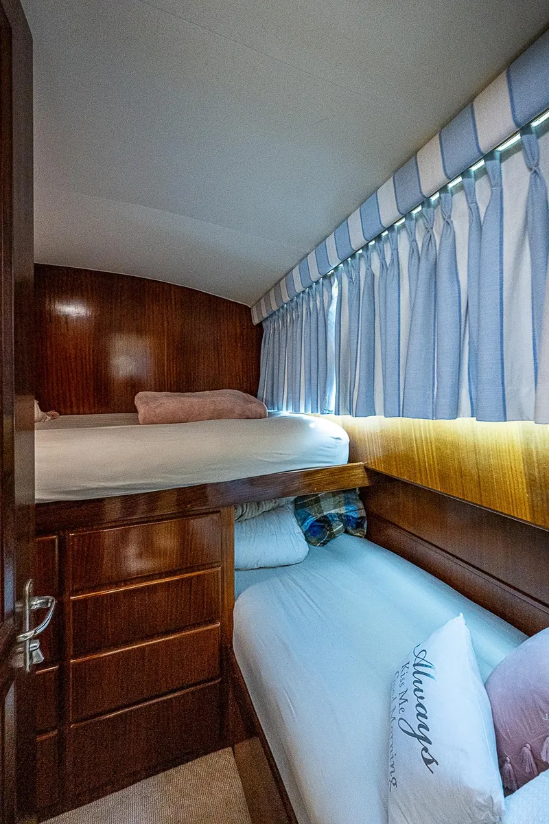Slide: The Image of 1986 Hatteras 72 Motor Yacht cabin with bunk beds and wood paneling. - 46