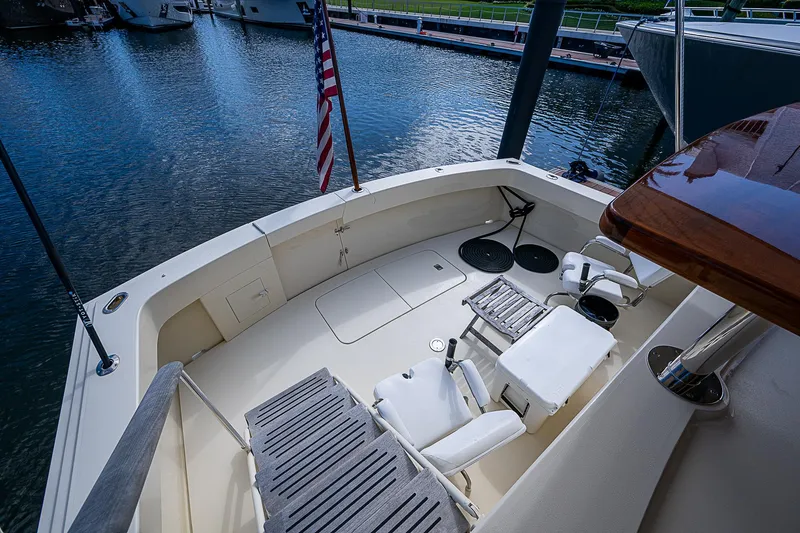 Slide: The Image of 1986 Hatteras 72 Motor Yacht deck with seating, docked by the water. - 9