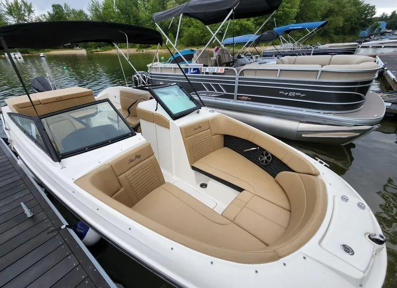 Slide: The Image of 2021 Sea Ray 230 SPXO boat docked at a marina with tan seating. - 6