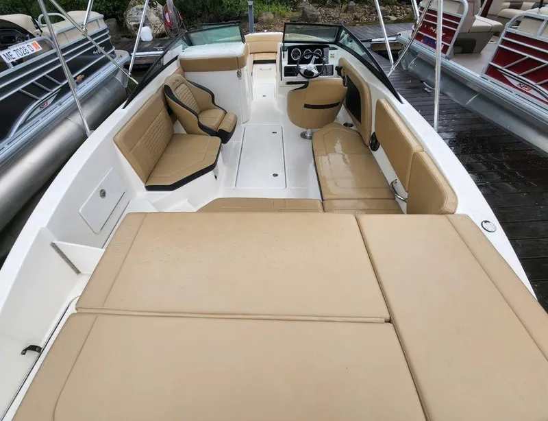Slide: The Image of 2021 Sea Ray 230 SPXO boat interior with tan seating and modern dashboard. - 9