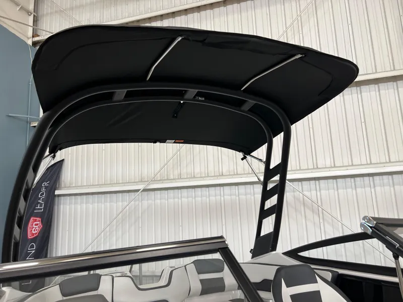 Slide: The Image of 2024 Yamaha Boats 195 S with black canopy and sleek interior design. - 6