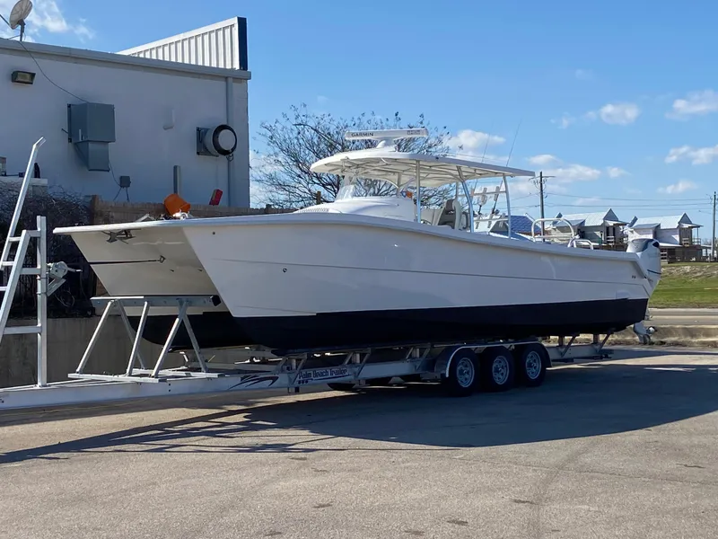 The Image of 2021 Twin Vee 36 Center Console boat on a trailer, parked outdoors. - 1
