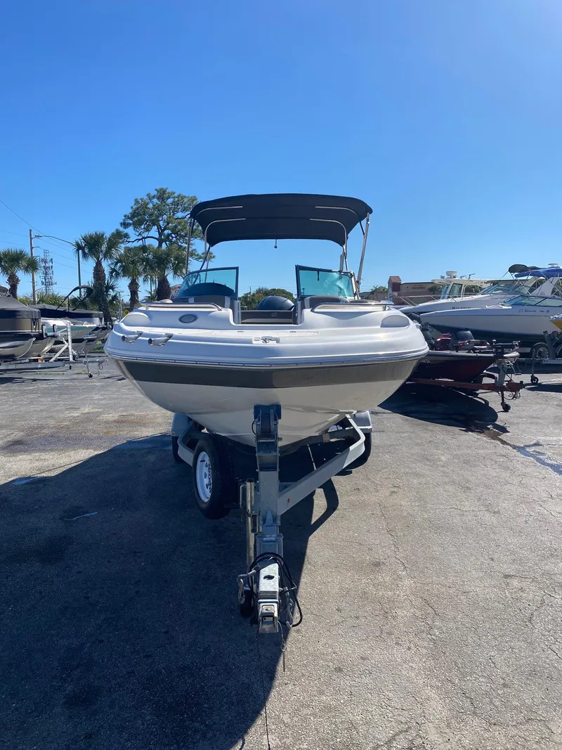 Slide: The Image of 2017 Hurricane SunDeck 2200 DC OB boat on trailer under clear blue sky. - 1