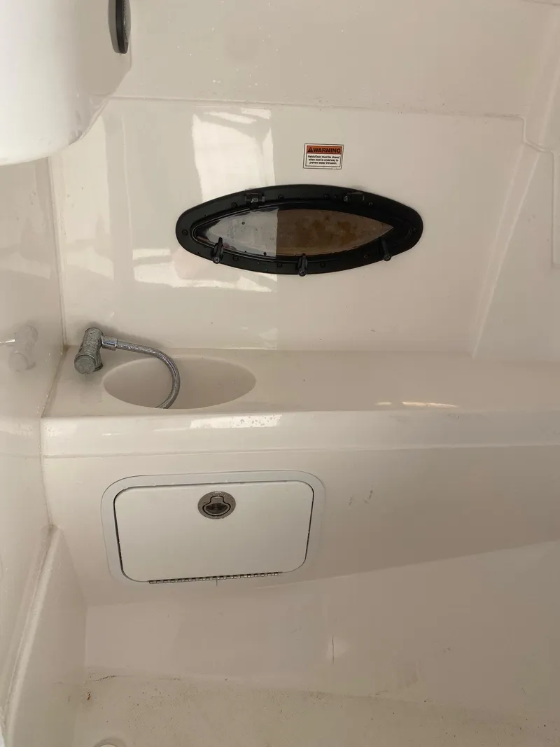 Slide: The Image of 2017 Hurricane SunDeck 2200 DC OB boat interior with sink and storage compartment. - 17