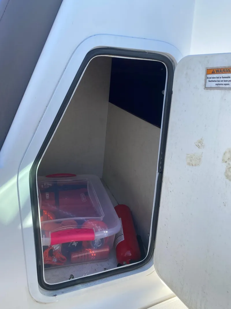 Slide: The Image of Storage compartment on a 2017 Hurricane SunDeck 2200 DC OB boat with safety equipment. - 25