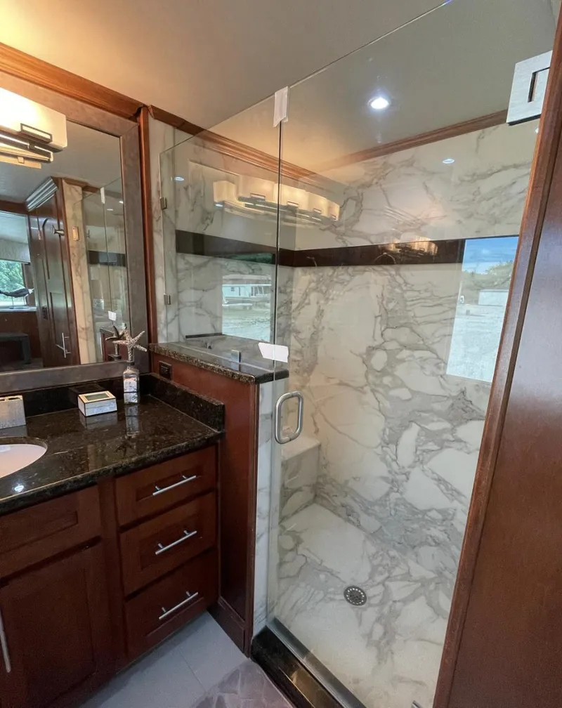 Slide: The Image of Luxurious bathroom in 2015 Stardust Cruisers houseboat with marble shower and wooden cabinetry. - 14