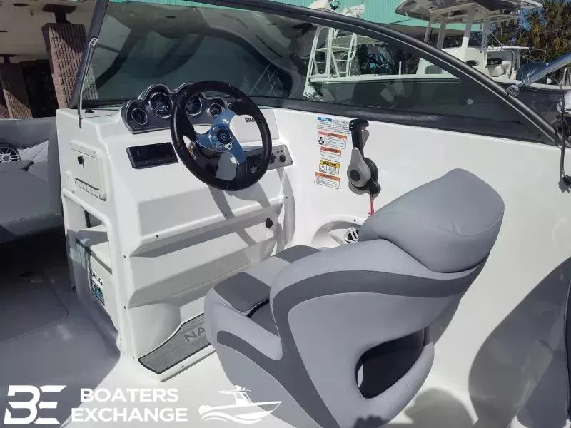 Slide: The Image of 2024 NauticStar 223 DC boat cockpit with steering wheel and captain's chair. - 6