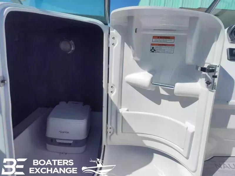 Slide: The Image of 2024 NauticStar 223 DC boat interior storage compartment with portable toilet. - 9