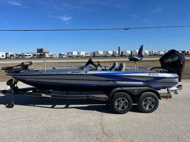 Slide: The Image of 2024 Triton 19 TrX Patriot bass boat on a trailer. - 0