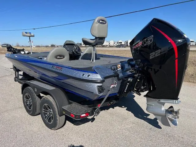 Slide: The Image of 2024 Triton 19 TrX Patriot bass boat with 225 HP motor on trailer. - 4