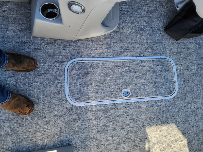 Slide: The Image of 2024 Trifecta 24RF LE 2 75 boat interior with carpeted floor and storage hatch. - 15