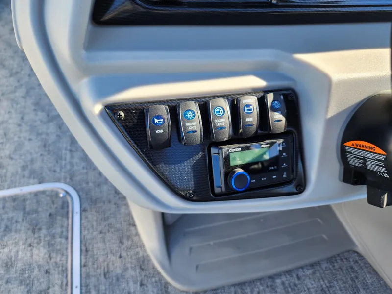 Slide: The Image of Control panel of 2024 Trifecta 24RF LE 2 75 boat with switches and stereo system. - 18