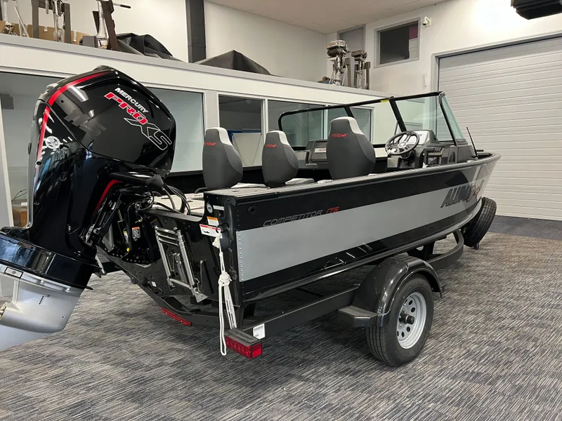 Slide: The Image of 2023 Alumacraft Competitor 175 Sport boat with outboard motor in showroom. - 2